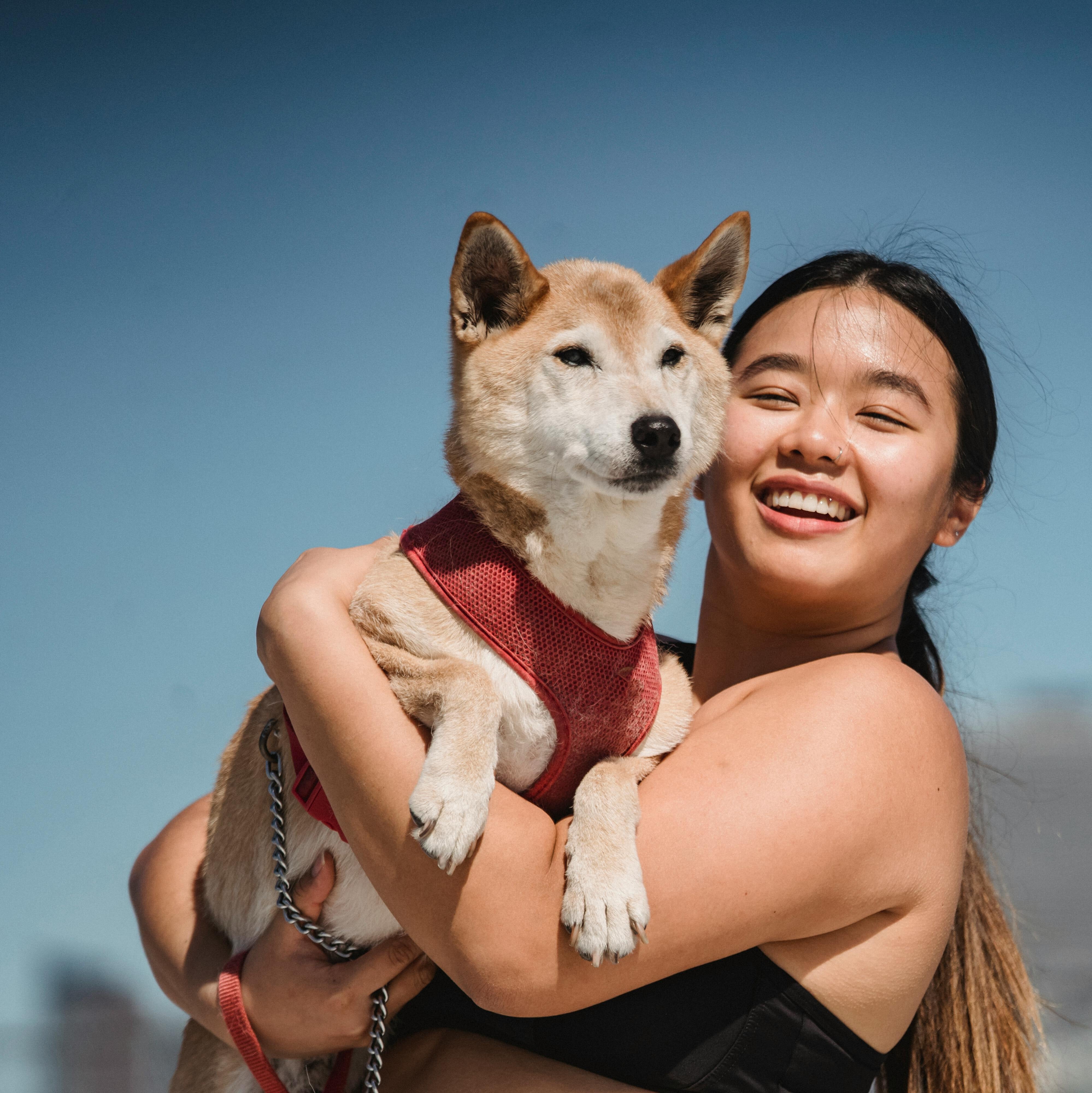 woman holding a dog with city in the background