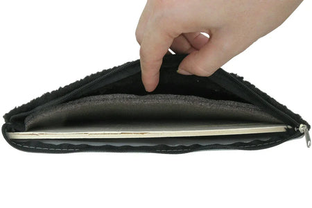 Hand opening a black zippered pouch on a white background