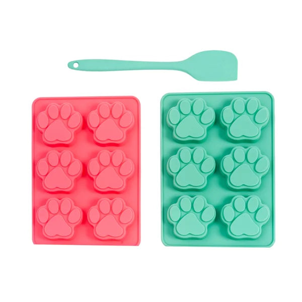 Two silicone mold trays with paw prints, one red and one green, on a white background.