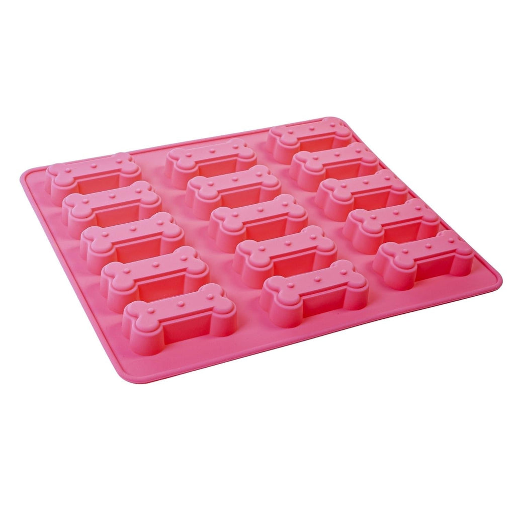 Pink silicone mold with bone-shaped cavities on a white background
