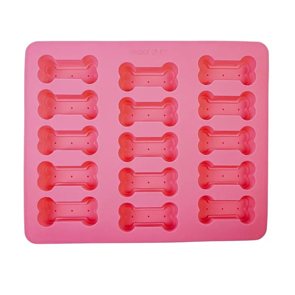 Pink silicone mold with bone-shaped cavities on a white background