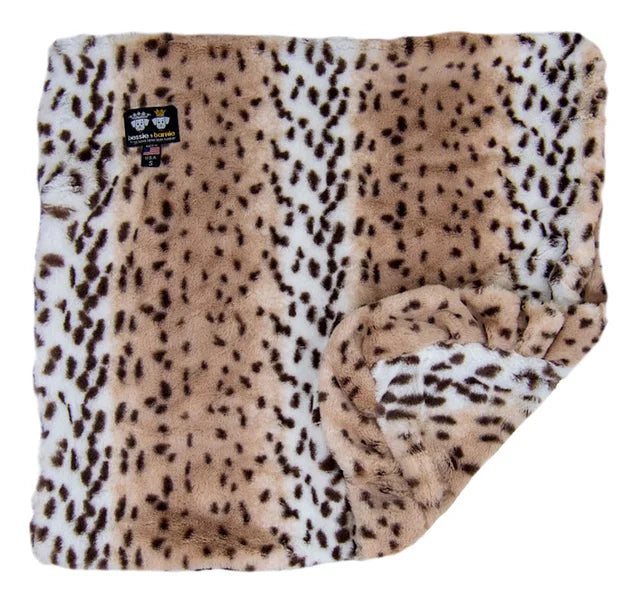 Folded leopard print blanket with a visible brand label on a white background