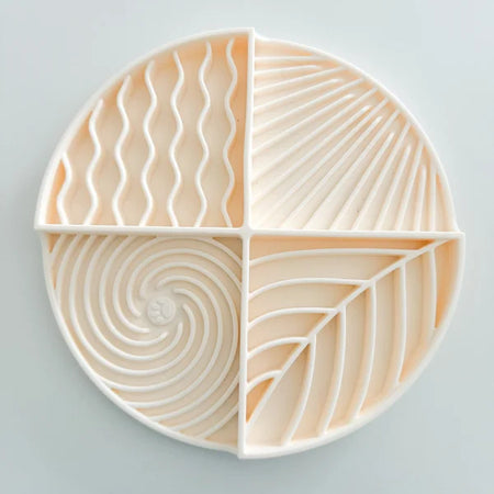 Round ceramic plate with geometric patterns on a light gray background