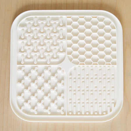 White plastic tray with various textured sections on a wooden surface