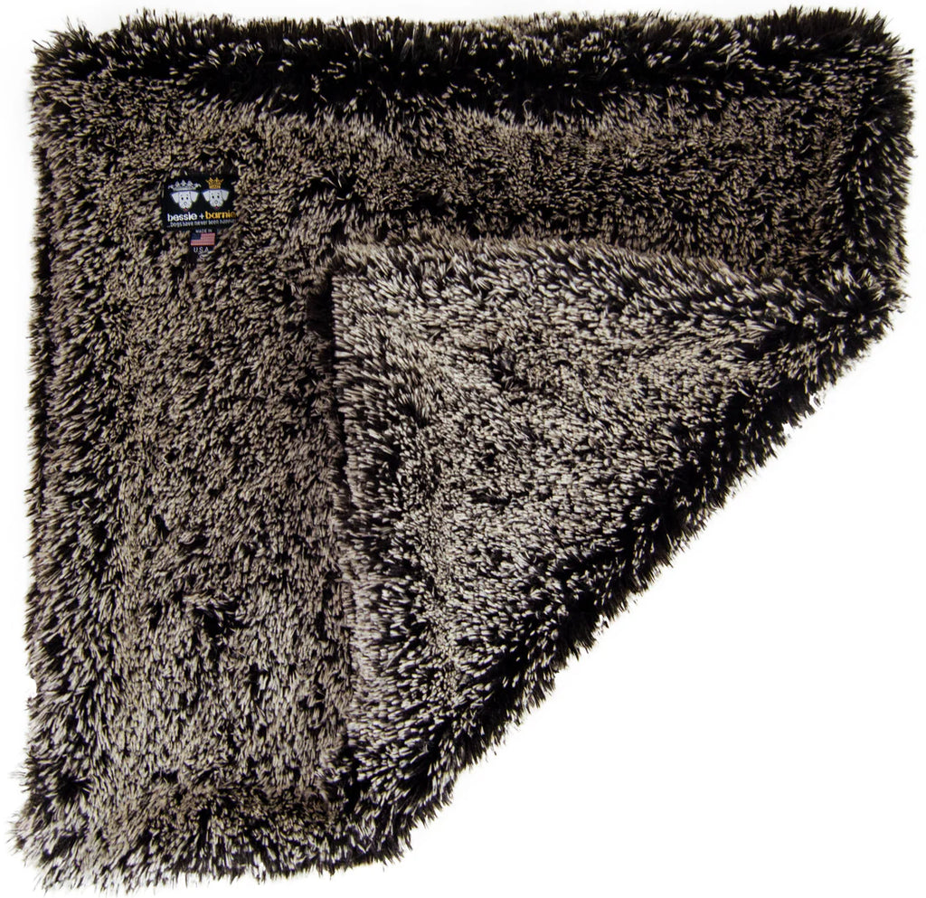 Fluffy brown blanket with a brand label on a white background