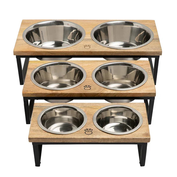Wooden pet feeding station with four stainless steel bowls on a white background