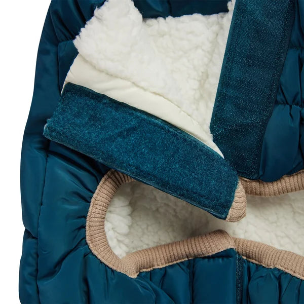 Close-up of a blue baby carrier with white lining and brown trim on a white background