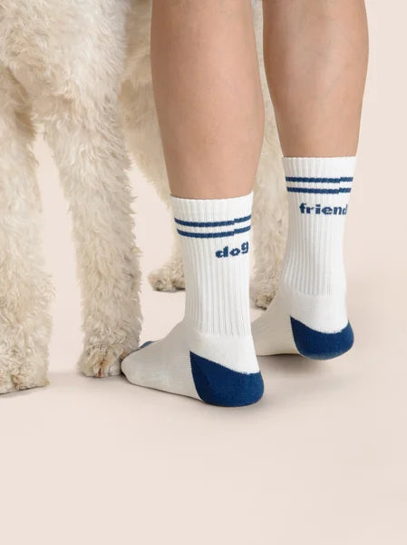 White socks with blue accents worn by a person, standing on a light background.