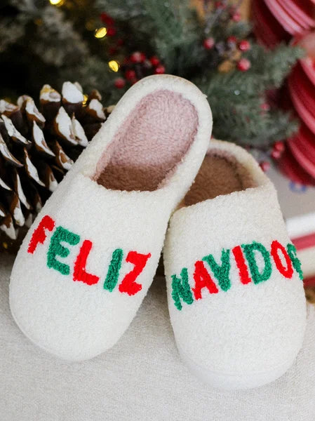 White slippers with 'Feliz Navidog' text in red and green on a light background.