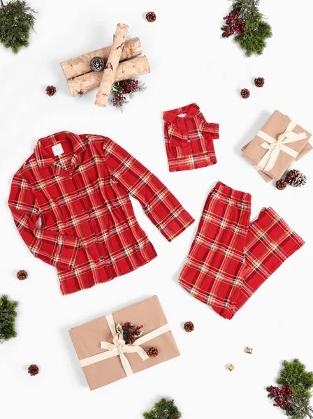 Red plaid pajama set with matching shorts on a white background with Christmas decorations.