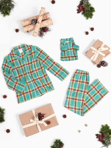 Plaid pajama set with matching children's outfit on a white background with Christmas decor.