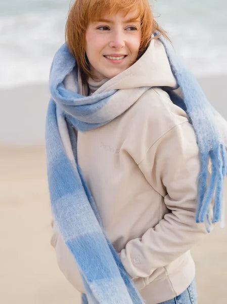 Person wearing a large blue and white scarf with a blurred background
