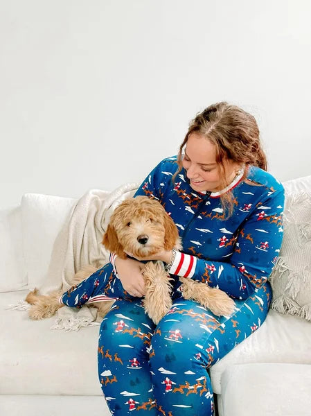 Woman in blue pajamas with a dog on a white couch