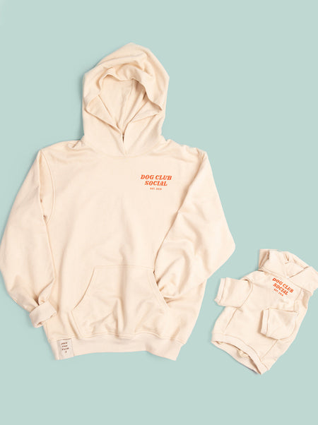 Beige hoodie with red text on a light blue background