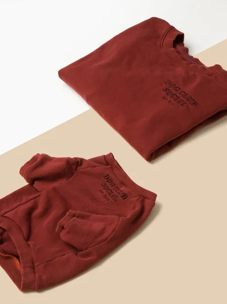Folded red hoodie on a beige surface