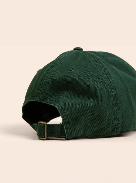 Green baseball cap on a beige background