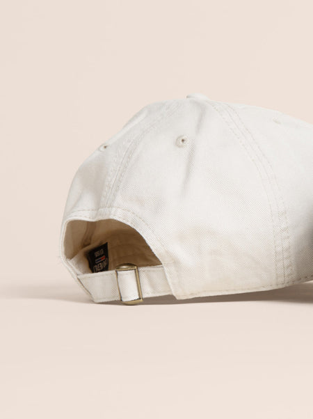 White baseball cap on a beige background