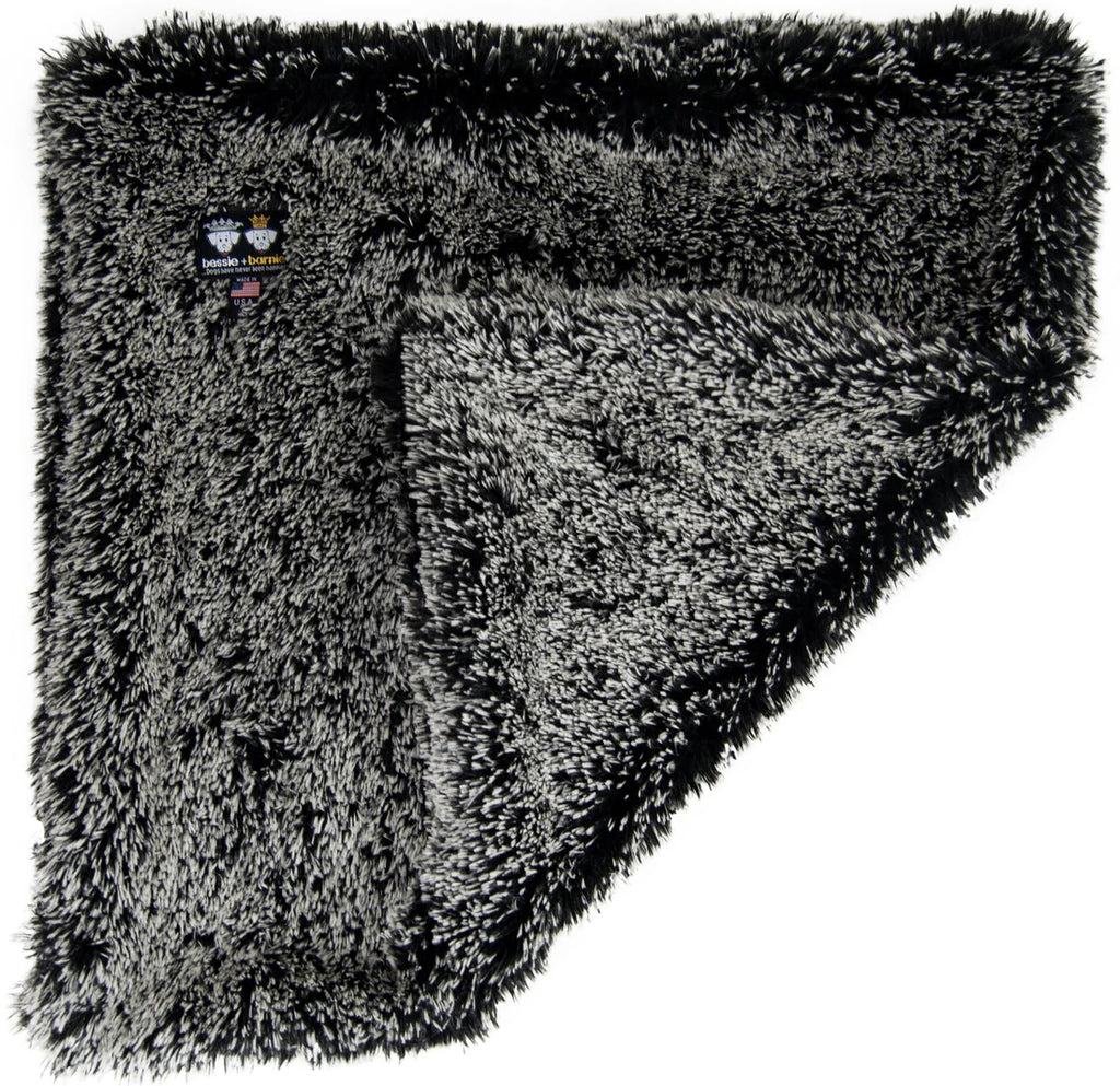 Fluffy gray blanket with a brand label on a white background