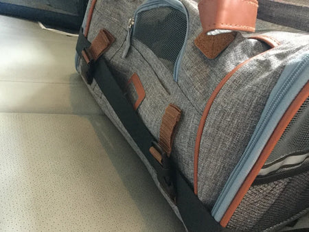 Gray pet carrier with brown accents on a light-colored floor