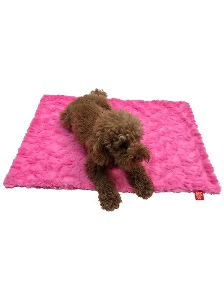 Brown dog lying on a pink textured mat with a visible brand logo.