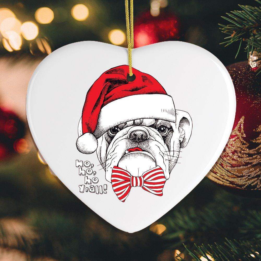 Heart-shaped Christmas ornament with a dog wearing a Santa hat and bow tie, hanging on a decorated tree.